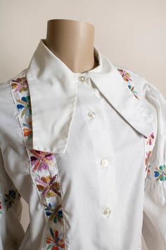 "FREE DOMESTIC SHIPPING! <3 ♥ Lovely vintage 1970s Bavarian style, embroidered flower blouse! ♥ Buttons up the front, interesting oblong collar! ♥ Long puff sleeves, with embroidered flower arm bands, giving it a slight extra puff! Elastic ends. ♥ In great condition! Dacron polyester & fine combed cotton, made in the USA. * measurements * Bust - 40\" Shoulders - 16\" Waist - 38\" Sleeve length - 22\" Length - 25\" Fits up to a large! ** I do ship worldwide! Vintage red Levi shorts, availa Bohemian Embroidered Collared Blouse, Vintage Collared Shirt With Floral Embroidery, Retro Collared Embroidered Top, Vintage Blouse With Floral Embroidery For Daywear, Retro Embroidered Collared Top, Fitted Cottagecore Blouse With Floral Embroidery, Cottagecore Fitted Blouse With Floral Embroidery, Vintage Embroidered Collared Blouse, Retro Floral Embroidered Button-up Top