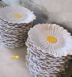 two large white plates with yellow centers on them sitting on a counter next to each other