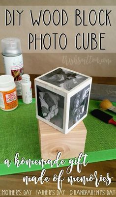 a wooden block photo cube sitting on top of a green mat next to other items