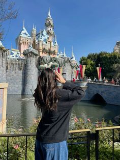 a woman taking a photo of the castle