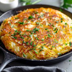 a close up of a pan with food in it on a table near utensils