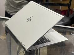 an open laptop computer sitting on top of a glass table