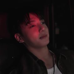 a young man sitting in the back seat of a car with his head turned to the side