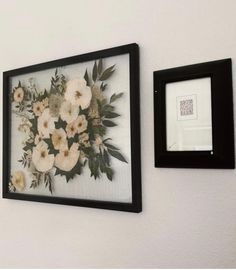 two framed pictures hanging on the wall with flowers