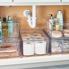 the bathroom is organized with clear containers and toiletries