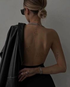 the back of a woman's body with tattoos on her upper and lower back