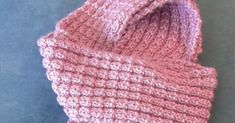 a pink knitted hat sitting on top of a table