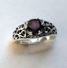 "You're beautiful A great design exposes sterling silver filigree ring with a deep red garnet stone set with prongs. (code- R2115) © 2011-2015, Artisanimpact Inc. All rights reserved. Construction and dimensions: Sterling silver, garnet Approximate diameter on top 7mm (0.27\") We can make any size, including quarter sizes. Please just indicate the requested size in the order. About our jewelry Artisanlook offers an exciting collection, designed and made by artisanimpact inc, especially for occas Elegant Garnet Jewelry, Elegant Garnet Round Jewelry, Elegant Garnet Jewelry With Round Stone, Wedding Silver Garnet Birthstone Ring, Sterling Silver Rings With Intricate Design, Elegant Silver Ruby Birthstone Ring, Elegant Garnet Filigree Ring For Wedding, Filigree Ruby Promise Ring, Elegant Solitaire Garnet Ruby Ring