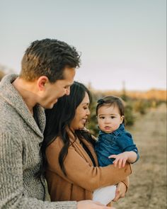 a man and woman holding a baby in their arms