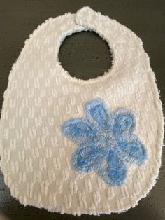 One baby bib made from a Vintage Cotton Chenille and an Appliqued Blue Chenille Flower.  This bib is backed with blue chenille.   Bib has a strong Velcro closure. Measurements:  8.5in wide and from top of bib to bottom 11.5in.  Neck opening measures 11in to 11.5 in around. Additional bibs are posted. I seek for 100% customer satisfaction so please reach out with questions, I'm happy to help. Thank you for visiting the store and please return as more things are listed regularly. Cute Handmade White Bib, Cute White Handmade Bib, Blue Cotton Machine Washable Bib, Cute Blue Bib For Playtime, Chenille Flower, Vintage Chenille, Flower Applique, First Baby, I'm Happy