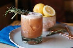 two glasses filled with drinks sitting on top of a white plate