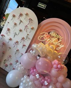 balloons and flowers are on display at a birthday party