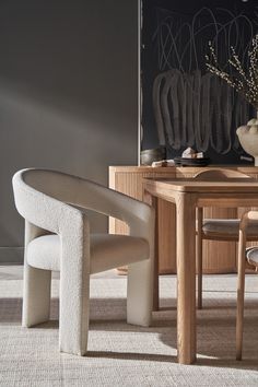 a dining room table with two chairs and a vase on top of it next to a chair