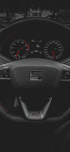 the dashboard of a car with red stitchs and gauges on it's dash