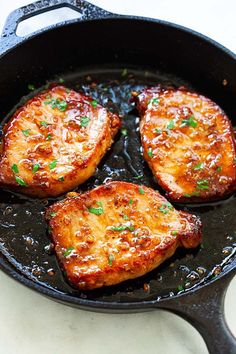 three pieces of meat cooking in a skillet