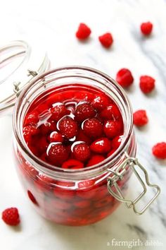 some raspberries are in a jar on the table