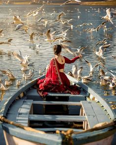 a woman in a boat surrounded by seagulls