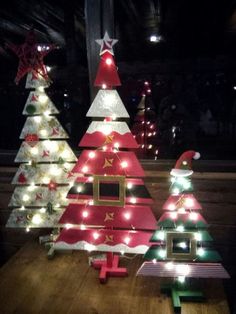 three christmas trees are sitting on a table