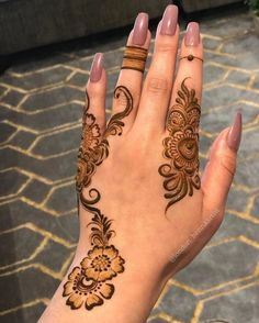 a woman's hand with henna tattoos on it