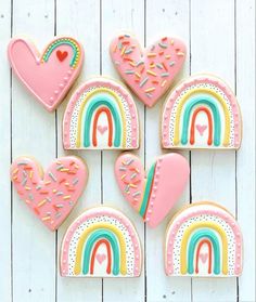 decorated cookies in the shape of rainbows and hearts on a white wooden background with text overlay