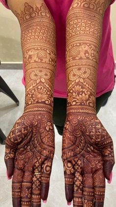 the hands and arms of a woman with henna tattoos