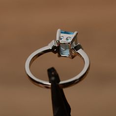 It is a real Swiss blue topaz topaz ring. The main stone is 6 mm*8mm emerald cut, weight about 2.0 carats The basic metal is sterling silver and plated with rhodium. To change the metal to a solid gold (white/rose) or platinum is also available, please ask for a quotation if you want. You can also go to my shop Home for more elegant rings: https://www.etsy.com/shop/godjewelry?ref=hdr_shop_menu Topaz is November birthstone. More topaz rings: https://www.etsy.com/shop/godjewelry?ref=hdr_shop_menu& Modern Sterling Silver Emerald-cut Diamond Ring, Classic Emerald Cut Topaz Ring With Prong Setting, White Gold Sterling Silver Ring With Rectangular Stone, Sterling Silver Diamond Cut Topaz Promise Ring, Fine Jewelry Blue Topaz Rectangular Rings, Sterling Silver Diamond Cut Topaz Ring For Promise, Fine Jewelry Topaz Ring With Rectangular Stone For Gift, Rectangular Topaz Ring As Gift, Fine Jewelry Style, Rectangular Topaz Ring Fine Jewelry Gift