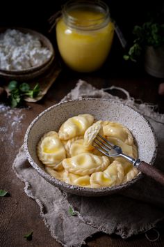 a bowl filled with ravioli next to a jar of butter and some other ingredients