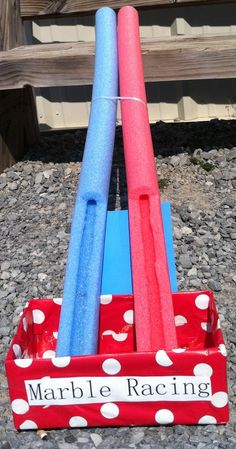 three plastic baseball bats sitting in a red and blue holder with white polka dots on it