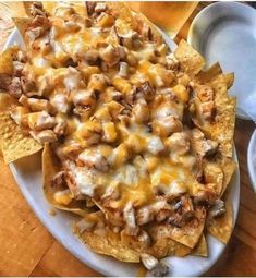 a white plate topped with nachos covered in cheese