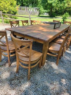 a wooden table and chairs sitting on gravel