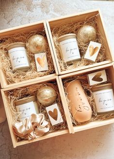 four candles in wooden boxes with gold foil hearts on them, one is empty and the other two are open