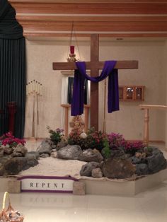 the altar is decorated with flowers, rocks and a crucifix on display