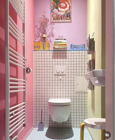 a bathroom with pink walls and white tiles on the floor, along with a toilet