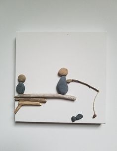 two small rocks sitting on top of a wooden branch