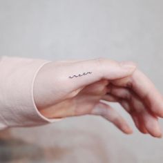 a woman's left hand with a small tattoo on the middle of her arm