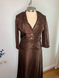 a woman's brown dress and jacket on a mannequin