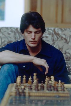 a man sitting on a couch playing chess