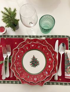 a place setting with christmas decorations and silverware