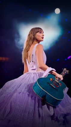 a woman in a purple dress holding a guitar