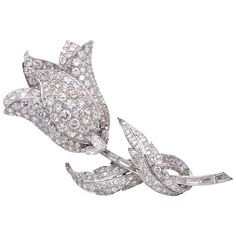 Platinum and Diamond Flower Clip- Brooch The stylized tulip with overlapping petals and leaves pavé-set with round diamonds, completed by a stem of baguette and fancy-shaped diamonds, altogether approximately 17.15 cts., Measuring 3 x 1 3/8 inches. Art Deco Diamond Brooch, Diamond Flower Brooch, Harry Winston Diamond, Graff Diamonds, Bridal Brooch, Art Deco Brooch, Leaf Motif, Tulip Flower, Diamond Brooch