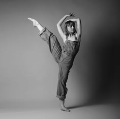 a woman in overalls doing a handstand