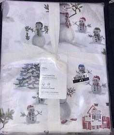 the package is packed with snowmen and christmas trees on white fabric, which has been folded