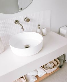 a white bathroom sink sitting under a mirror