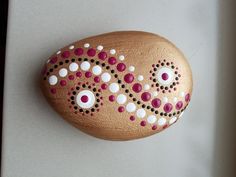 a painted rock sitting on top of a white surface