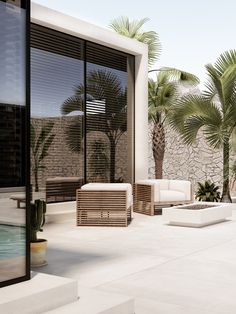 an outdoor living area with couches, chairs and palm trees