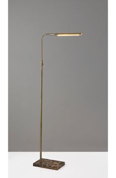 a lamp that is on top of a white table with a gray wall in the background