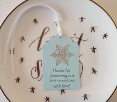 a white plate with a snowflake ornament hanging from it's side