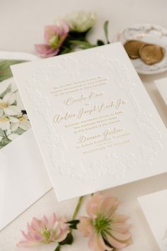 the wedding stationery is laid out on top of the table with flowers and cards