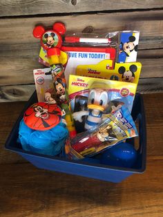 a blue basket filled with toys on top of a wooden table