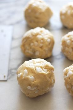 several cookies with white sprinkles sitting on a counter top, ready to be baked